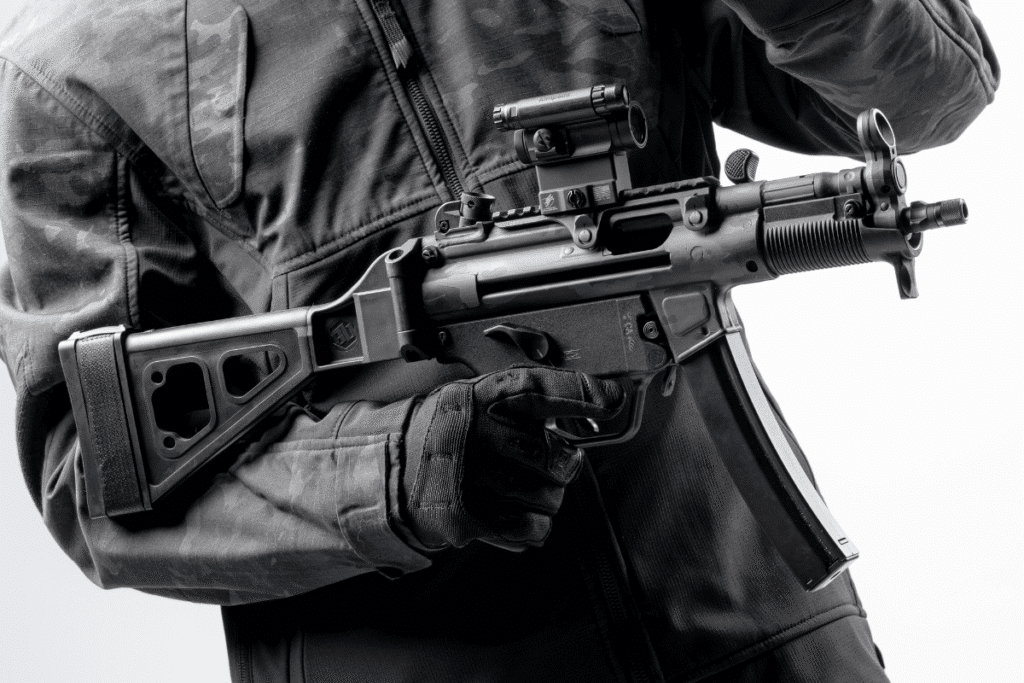 Black-and-white photograph of a person holding a firearm with an SB Tactical brace